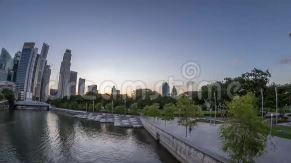 新加坡摩天大楼天际线与白色安德森桥附近的esplanade公园白天到夜间时间推移视频的预览图