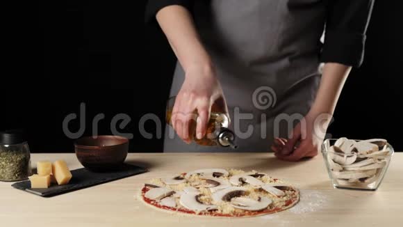 专业厨师用橄榄油喷洒比萨饼以增强用比萨饼配料装饰的桌子上的风味面团的概念视频的预览图