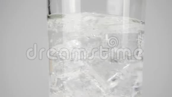 冰块旋转并漂浮在带有白色背景气泡的纯净淡水的玻璃中呆在家里吃饭的概念视频的预览图