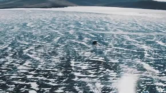 汽车漂流在冰冻的贝加尔湖冬季景观与清澈光滑的冰空中观景视频的预览图