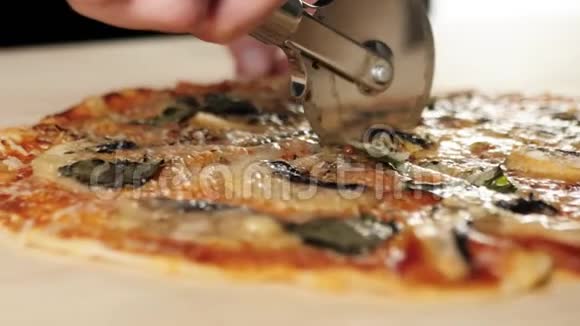 专业厨师用专用披萨刀将披萨切成两部分烹饪美味披萨的概念关门视频的预览图