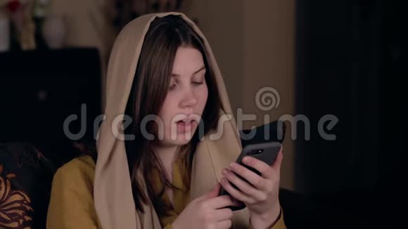 年轻漂亮的基督徒女人头上戴着围巾白种人的外表坐在扶手椅上看书视频的预览图