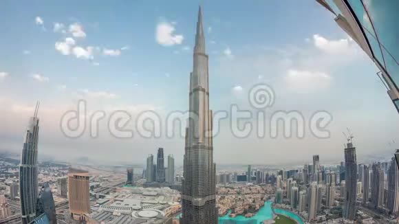 迪拜市中心的全景式天际线从购物中心喷泉和哈利法塔从白天到晚上的空中延伸视频的预览图