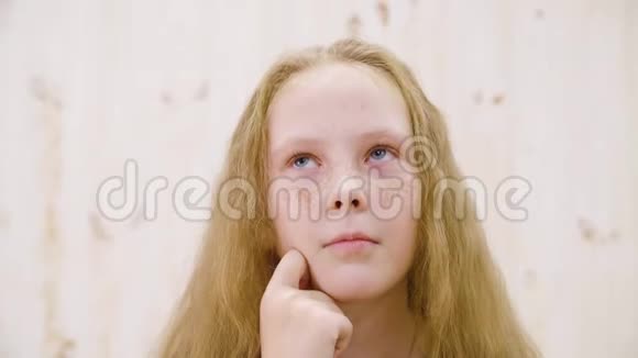 在灯光工作室里一个满头雀斑的红发女孩若有所思特写面部思考少女视频的预览图
