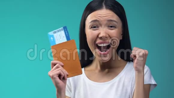 兴奋的亚洲女士持护照和机票在国外工作移民视频的预览图