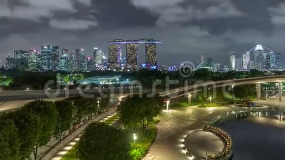 鸟瞰新加坡城市天际线与彩色喷泉在玛丽娜河坝花园夜晚时光飞逝视频的预览图