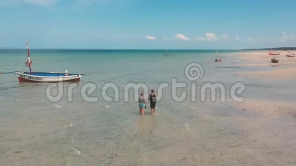 度假夫妇在海滩的浅海中散步视频的预览图