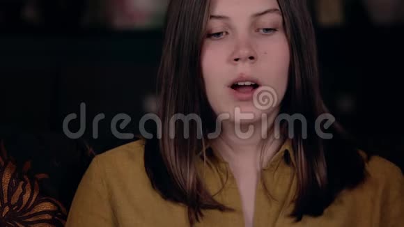 一个年轻的欧洲女孩很累在家里的扶手椅上打哈欠疲劳的概念视频的预览图