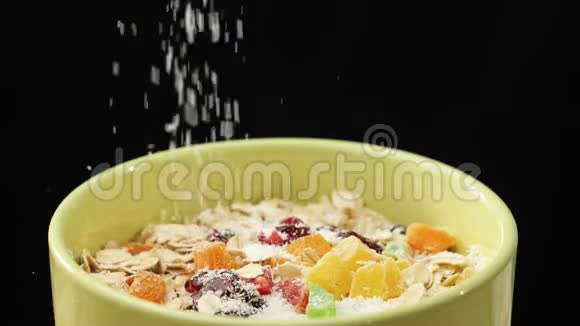 新鲜健康食品白色的椰子片和燕麦片蜜饯葡萄干和红莓一起放在绿色的碗里视频的预览图