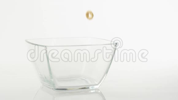 新鲜健康食品黄色的谷物落在白色背景上透明的方形碗里健康早餐的概念视频的预览图