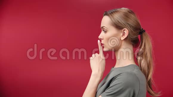在红影院背景下一个可爱的金发女孩的半脸半脸展示了她的手势视频的预览图