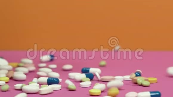 散落在粉红色背景上的药丸视频的预览图