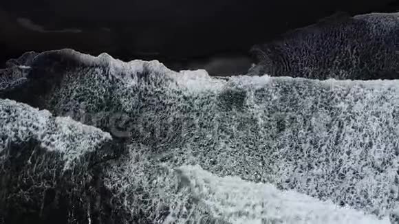 海浪在沙滩上随着黑色的沙滩破碎视频的预览图