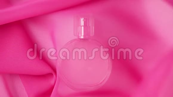 椭圆形表面瓶与粉红色香水或精油是在白色桌子下的粉红色织物粉红色的织物视频的预览图