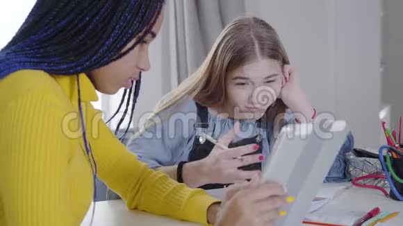 白种人女孩看平板电脑屏幕和手势的肖像非裔美国人青少年咨询最好的朋友视频的预览图