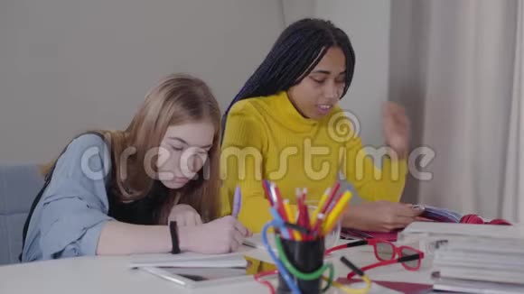 在家做作业的朋友非裔美国女孩做胜利手势并显示笔记本结束学生视频的预览图