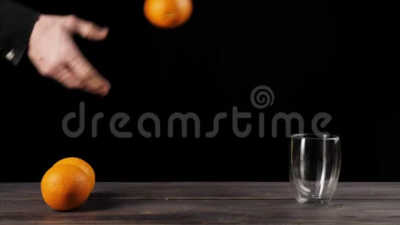 当橘子到达玻璃后宽手从桌子上取出橘子依次扔进双壁玻璃中视频的预览图