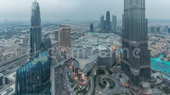 迪拜市中心的全景式天际线从购物中心喷泉和哈利法塔从白天到晚上的空中延伸视频的预览图