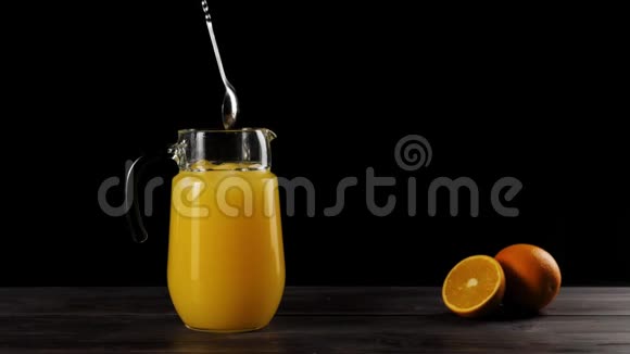 女孩手拿调酒师勺子用新鲜橙汁搅拌冰块慢动作视频的预览图