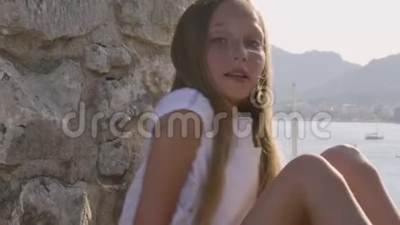 幸福少女少年画像上的石墙和山景美丽的女孩在岩石墙上拍照视频的预览图