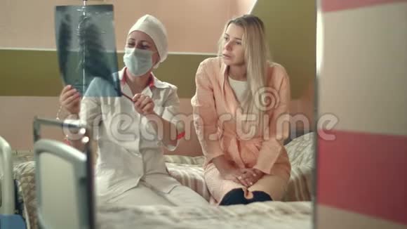 专业医生拿着x光和坐在床上的年轻女性病人交谈视频的预览图