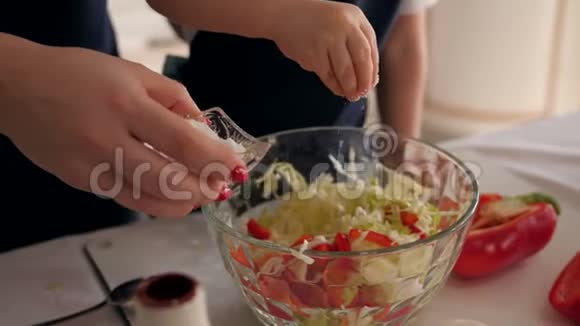 一个小女孩学做饭她在蔬菜沙拉里加盐视频的预览图