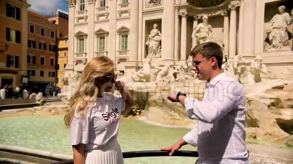旅行夫妇扔硬币在特雷维喷泉罗马意大利好运快乐的年轻夫妇微笑着亲吻视频的预览图