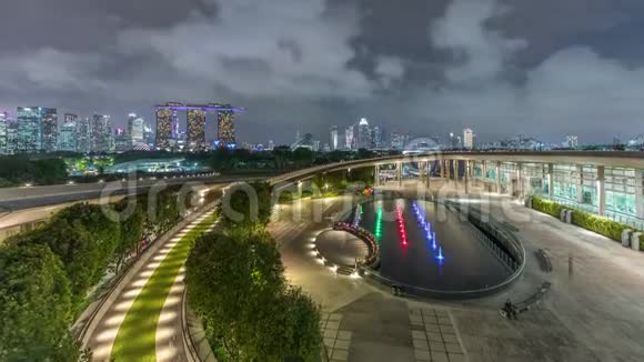 鸟瞰新加坡城市天际线与五颜六色的喷泉在码头拦河花园夜间时间推移视频的预览图