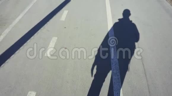 阳光明媚的一天一个男人在人行道上的影子视频的预览图