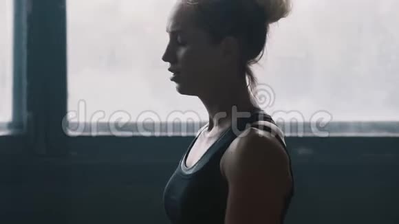 镜头跟随年轻美丽的运动疲惫的金发女人走在大空健身房准备锻炼慢动作视频的预览图