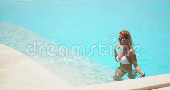 穿着白色泳衣走出水面的苗条女人视频的预览图