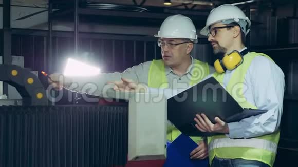 男雇员正在一个工厂单位进行讨论工业工厂的男工程师视频的预览图