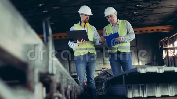 专业重工工程师男性工人在一个有建筑用品的工厂里谈话视频的预览图