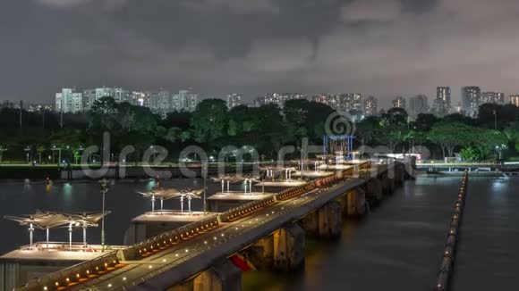 鸟瞰新加坡城市天际线与桥在码头拦河花园夜间时间推移视频的预览图