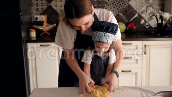 一位母亲教她的小女儿揉饼干面团视频的预览图