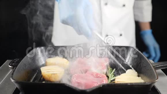 厨师用火钳在烤架上用肉煮土豆慢动作冒烟高清高清视频的预览图