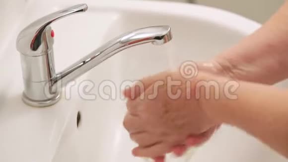 老年妇女在自来水龙头下用肥皂洗手可作为ncov期间的卫生图示概念视频的预览图