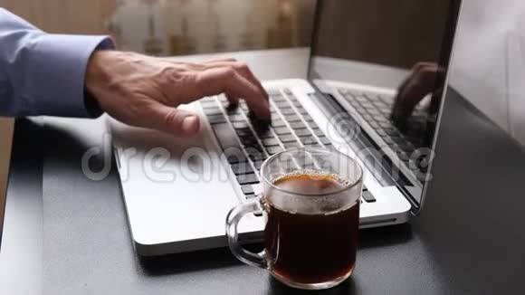 电脑键盘男人在电脑上打字喝咖啡视频的预览图