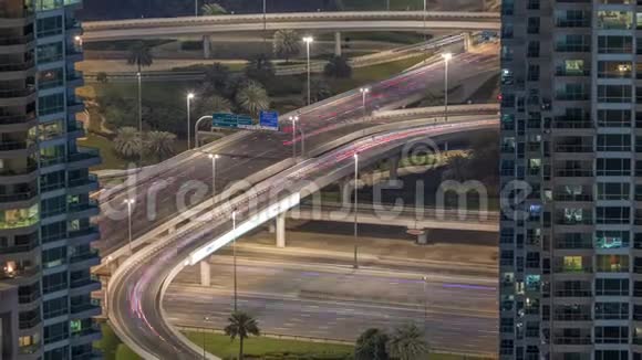 迪拜码头高速公路出口之间的摩天大楼意大利通心粉交接处空中夜晚时间视频的预览图