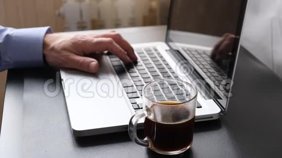电脑键盘男人在电脑上打字喝咖啡视频的预览图