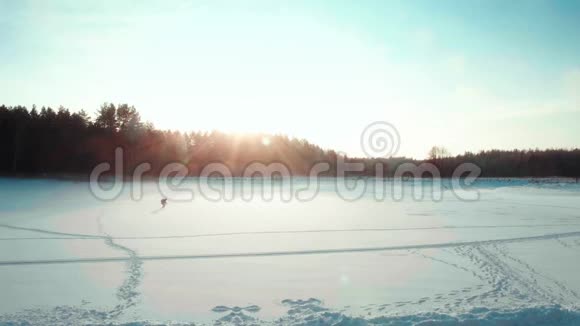 徒步旅行者在冬天的田野里跳跃滑稽的剪影视频的预览图