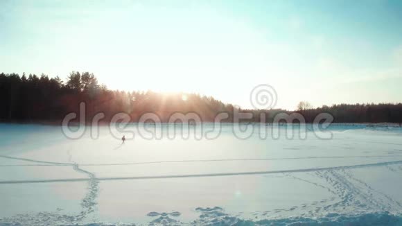 冬天游客在田野里跳跃滑稽的剪影把手臂举到空中视频的预览图