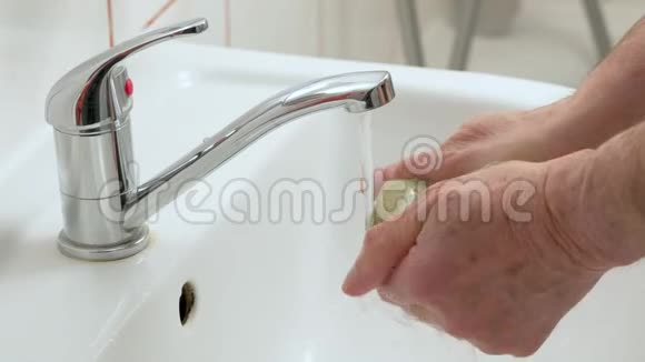 长者用自来水龙头洗手详情冠状病毒爆发时的卫生视频的预览图