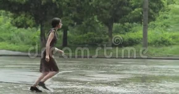 一个年轻的女人跑到房子的拱门躲避大雨四处看看慢动作4K视频视频的预览图