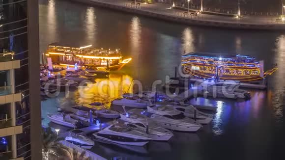 豪华游艇停在迪拜码头码头码头码头与城市鸟瞰夜间时间流逝视频的预览图