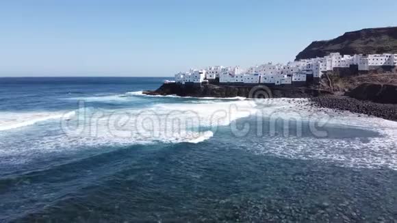 海浪的空中镜头和白色房屋的自然小镇典型的西班牙景色视频的预览图