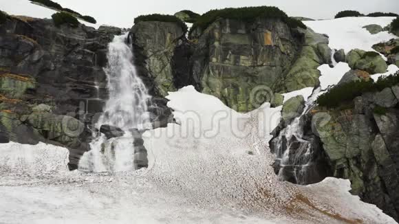 瀑布斯柯克在高塔特拉斯斯洛伐克阴天的春天岩石覆盖着肮脏的融化的雪视频的预览图