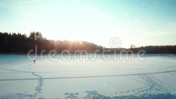 游客在冬天穿过田野在冰冻的湖面上视频的预览图