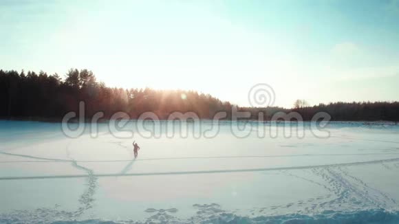 背包客在冬天的田野里跳跃滑稽的剪影把手臂举到空中视频的预览图