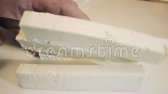 男性用刀子在长片上的玻璃上切割奶酪寿司的奶酪视频的预览图